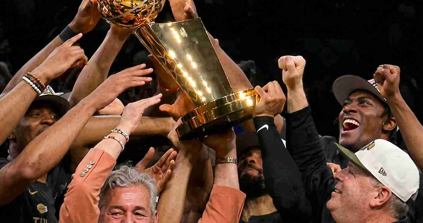 Team of diverse hands lifting a large gold trophy in celebration