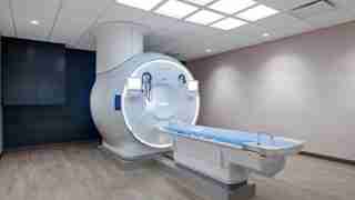 Large MRI scanner in a radiology room with a patient table ready for imaging