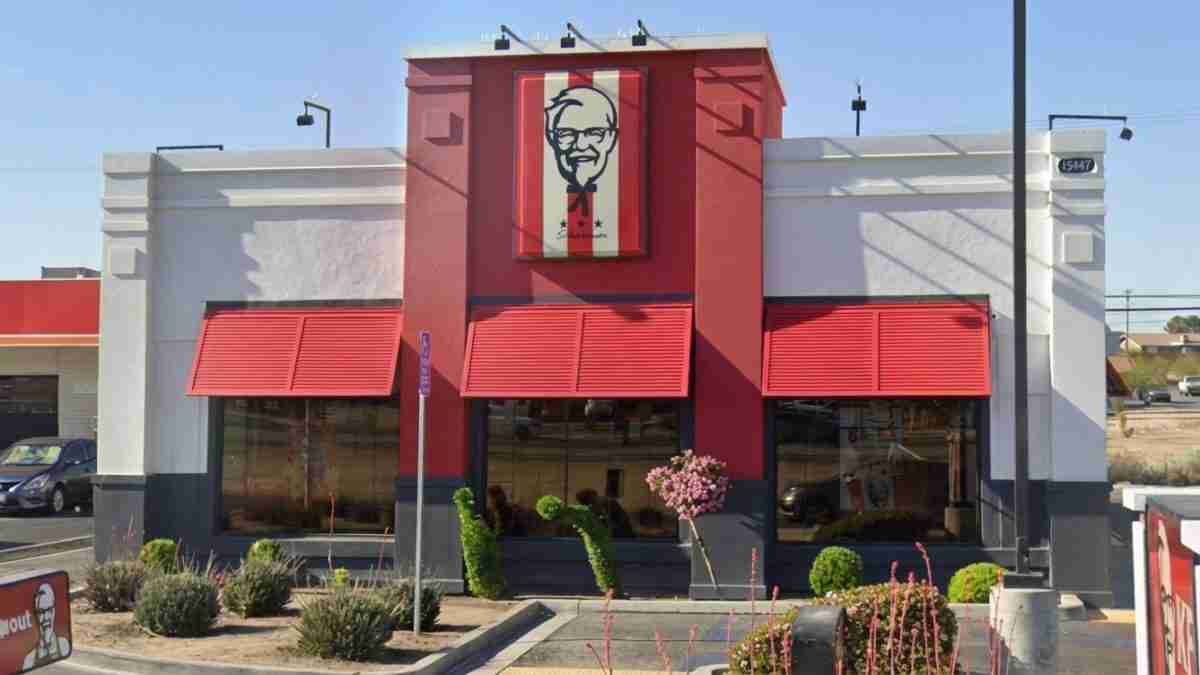 KFC fast-food restaurant with red facade, large Colonel Sanders sign, and red awnings over the windows in front.